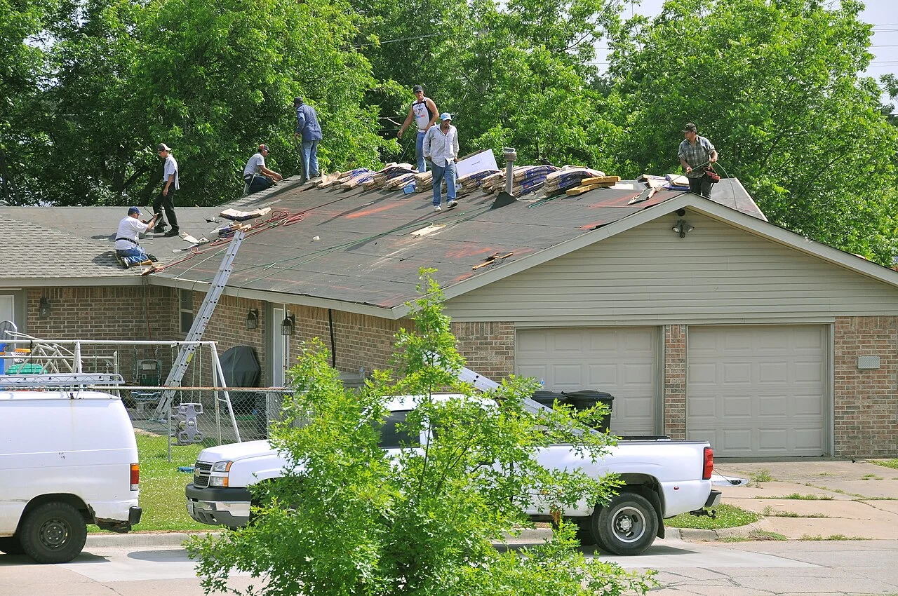 A roofing crew replacing shingles on a tornado-damaged home in Oklahoma